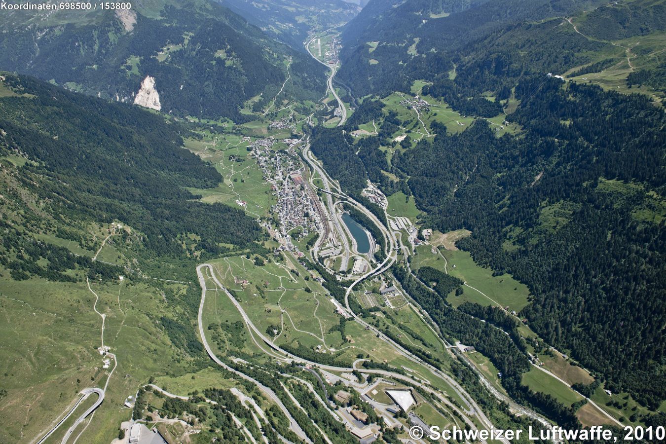 Airolo (Position: 2'689'868.85, 1'154'054.12). Blick über die Tremola-Strasse südwärts nach Airolo in die Valle Leventina mit Ambri-Piotta im Hintergrund-Mitte; Siedlung auf der Anhöhe rechts: Nante; Taleinschnitt gegen obere Bildhälfte links: Val Canaria.